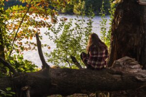 female-sitting-tree-enjoying-view-with-sea-scaled