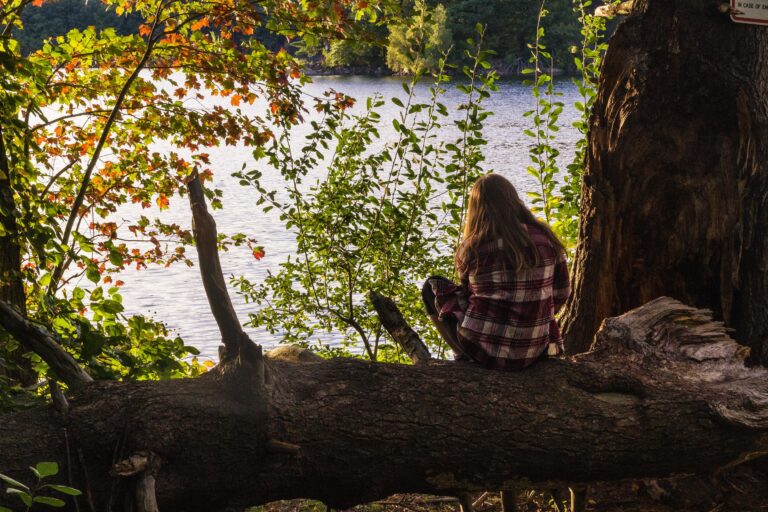 female-sitting-tree-enjoying-view-with-sea-scaled